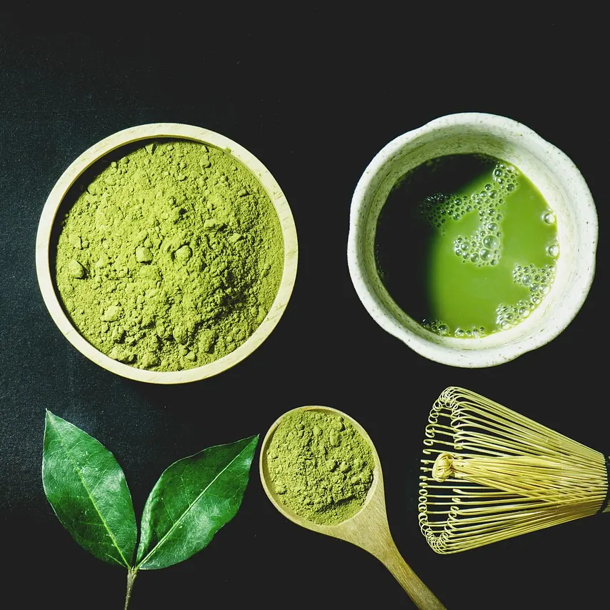 Temporary photo: matcha powder, a bowl of matcha and a bamboo whisk
