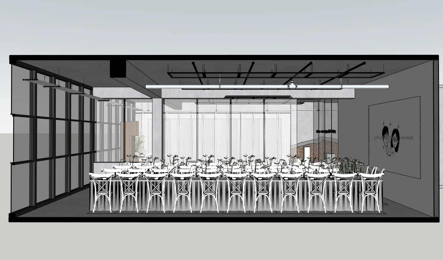 Reception layout at Nhue Studio: one long banquet table under black track lighting, set against the studio's glass wall.